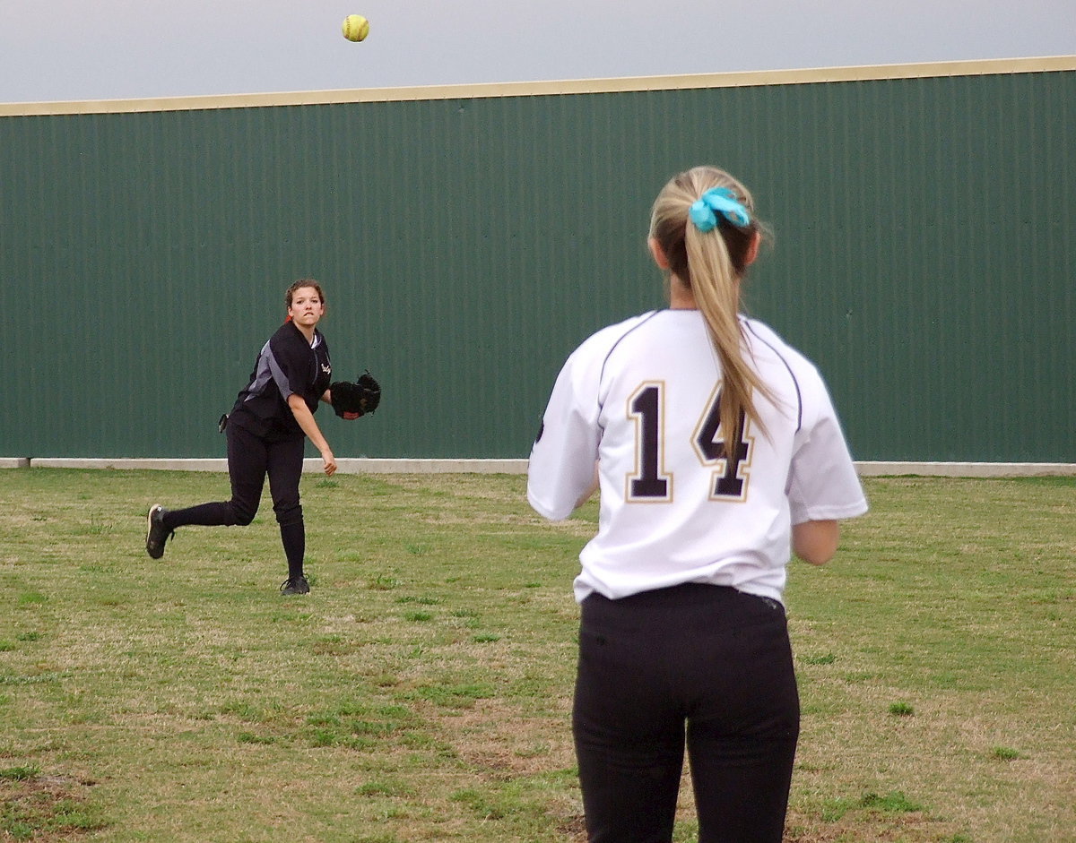 Image: Lady Gladiator Morgan Cockerham(8) plays toss with Kelsey Nelson(14) in preparation for game one against Bosqueville.