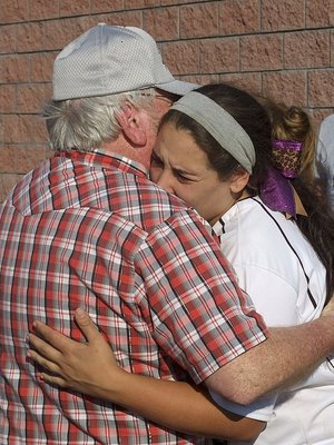 Image: Senior Alyssa Richards(9) struggles with the moment in the arms of her grandfather, Greg Richards after playing her final game for the Lady Gladiators.