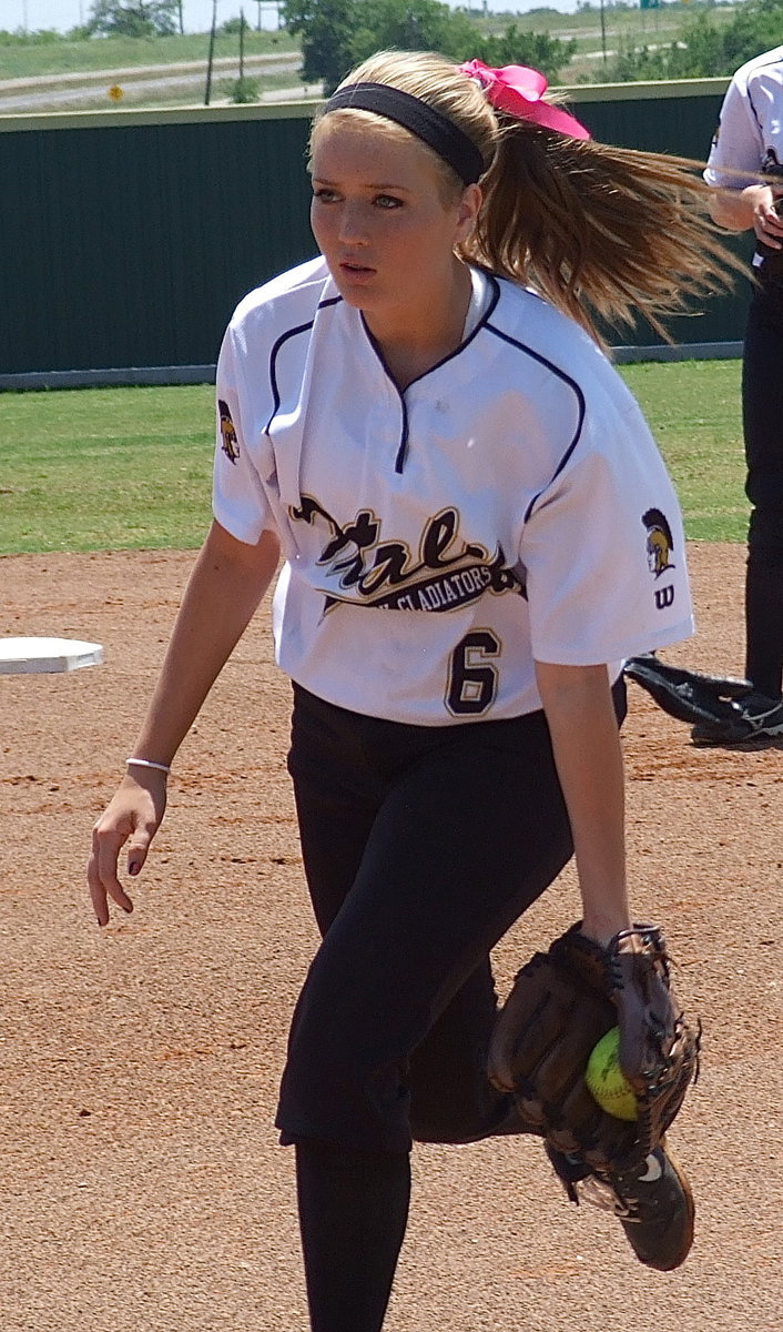 Image: Italy’s Hannah Washington(6) fields a practice grounder before game time.