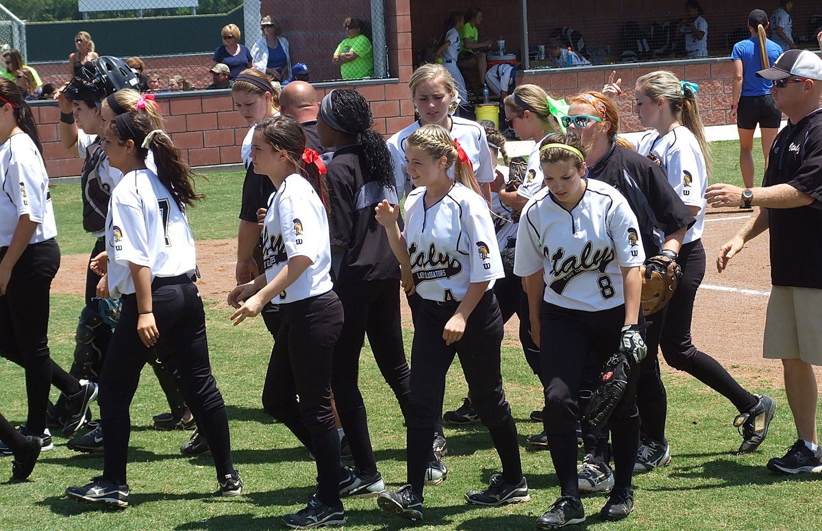 Image: The Lady Gladiators break the huddle and then prepare to bat.