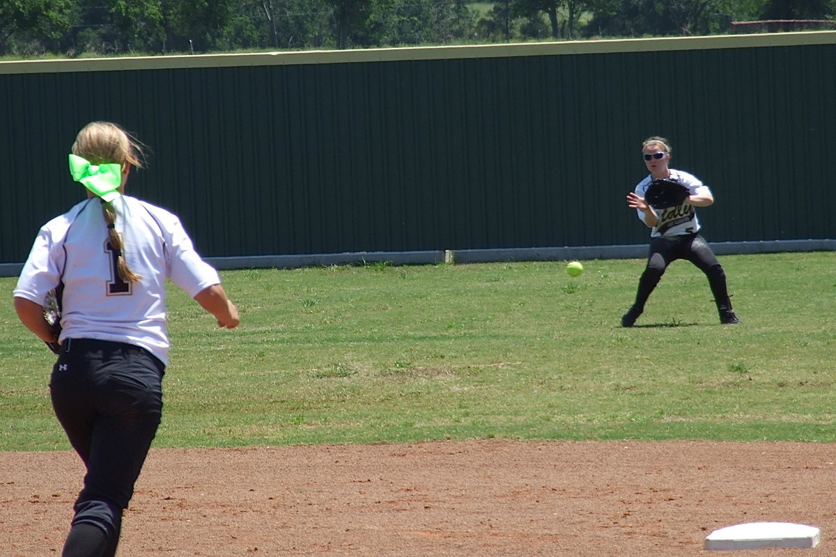 Image: Left fielder Tara Wallis(5) fields a grounder hit in her direction with second baseman Bailey Eubank(1) moving into position for the relay in.