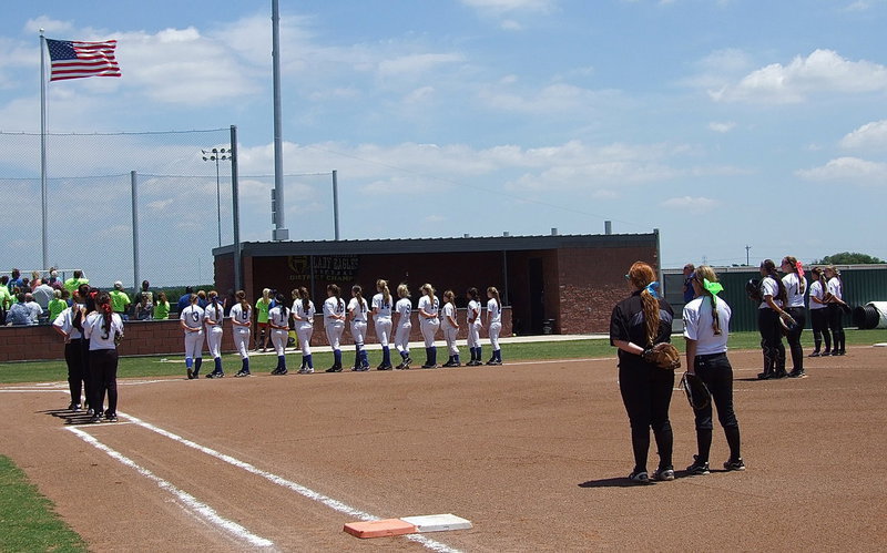 Image: The Lady Lady Gladiators and the Bosqueville Lady Bulldogs show respect during the National Anthem before going to war in a regional quarterfinal showdown played in nearby Hillsboro.