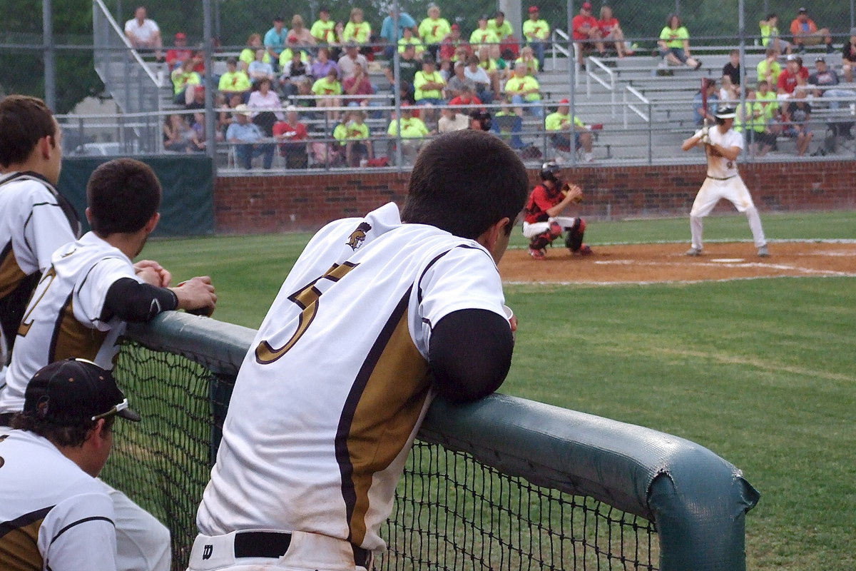 Image: Ried Jacinto(5) watches from the dugout with Cole Hopkins(9) just moments away from hitting a fly ball double into right field in the top of the fourth-inning.