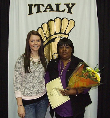 Image: 8th grade’s Favorite Teacher of the Year is Vivian Moreland. Brooke DeBorde presents Ms. Moreland with a certificate and bouquet.