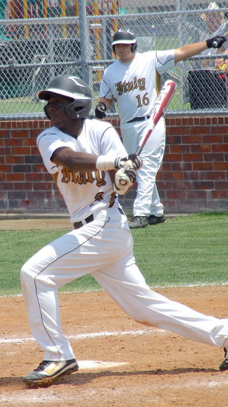 Image: Kevin Roldan(16), watches from the batter’s circle as Marvin Cox(3) records a hit with teammate Reid Jacinto(5) already at first base.