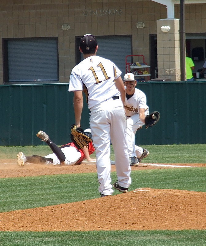 Image: Pitcher, Tyler Anderson(11) throws to, first baseman, Cole Hopkins(9) in order to keep Trenton tight to the bag.