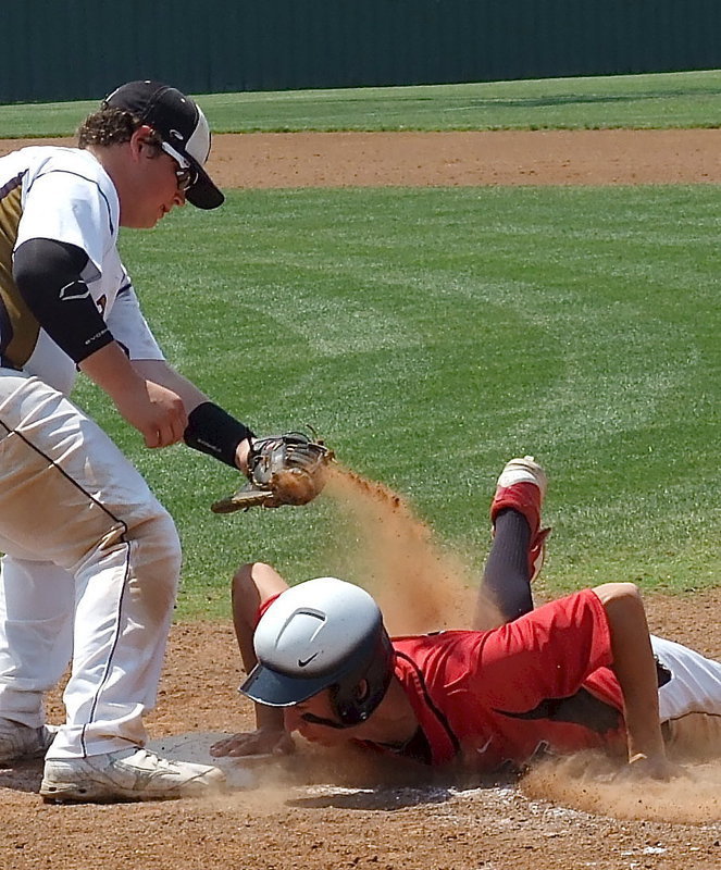 Image: First baseman, John Byers(18) scoops the throw from the mound and goes for the tag to hold a Trenton runner to the bag.