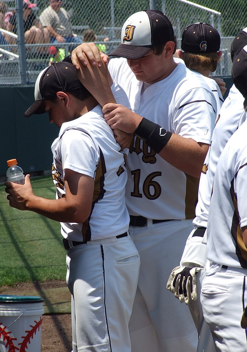 Image: Gladiator Kevin Roldan(16), a junior, stretches out the pitching arm of Tyler Anderson(11) as the junior pitcher gets ready for one of the biggest games in his career.