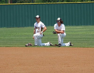 Image: Outfielders Chase Hamilton(10) and Kyle Fortenberry(14) look on as their infielders conclude their pre-game routine.