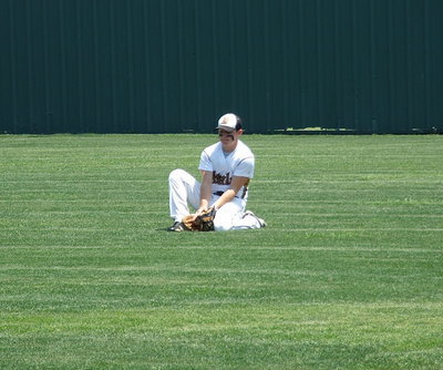 Image: Senior right fielder, Hayden Woods(8), work on securing a grounder during the pre-game.