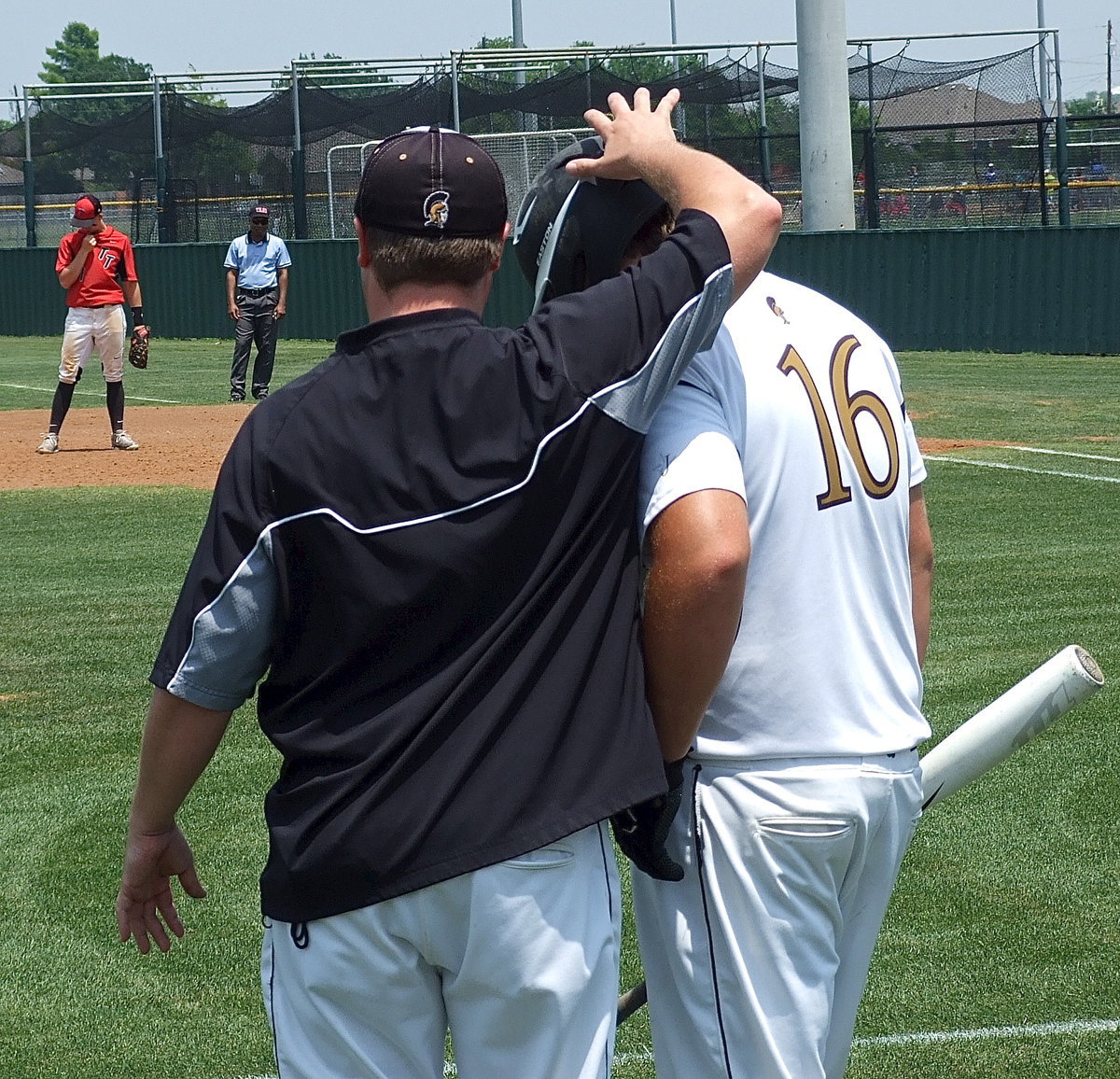 Image: Italy Baseball head coach Josh Ward talks strategy with Kevin Roldan(16) before Roldan goes up to bat.