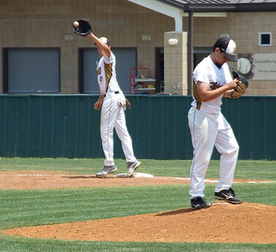 Image: Cole Hopkins(9) warms up at first base while Tyler Anderson(11) takes some practice pitches between innings.