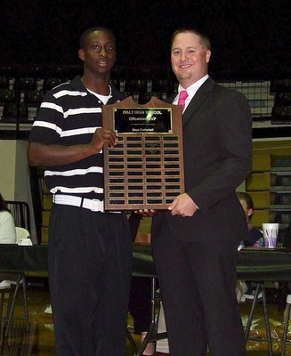 Image: Senior Marvin Cox receives the Boys Offensive MVP Award in basketball with assistant varsity basketball coach Josh Ward making the presentation.