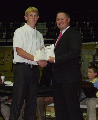 Image: Sophomore Cody Boyd receives his certificate as a member of the Italy Baseball team from head coach Josh Ward.