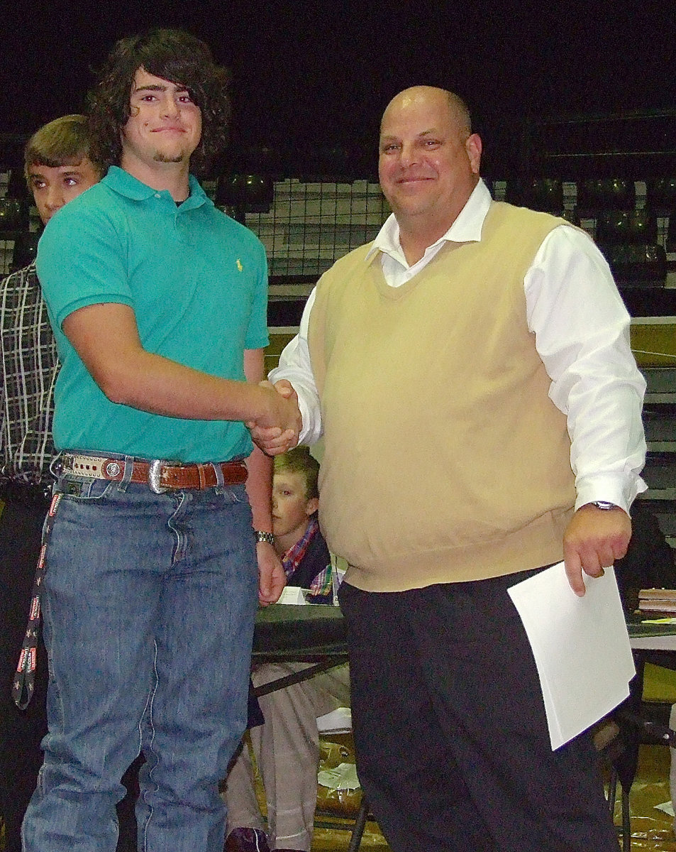 Image: Assistant baseball coach Brian Coffman presents sophomore Kyle Fortenberry with a certificate as a member of the Italy Baseball team.