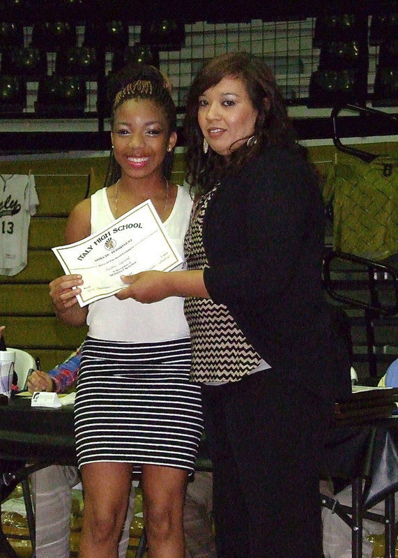 Image: Ryisha Copeland receives her certificate as a member of the Lady Gladiators basketball team from assistant basketball coach Tina Richards.