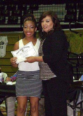 Image: Ryisha Copeland receives her certificate as a member of the Lady Gladiators basketball team from assistant basketball coach Tina Richards.