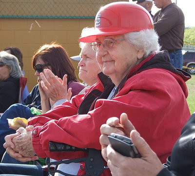 Image: Alice Riddle, in her Louisville Slugger plastic batting helmet, and daughter, Joy Moneyhon, cheer on the Lady Gladiators during a district softball home game. Alice wears a plastic Louisville Slugger helmet as a precaution after a foul ball hit her in the head last fall.