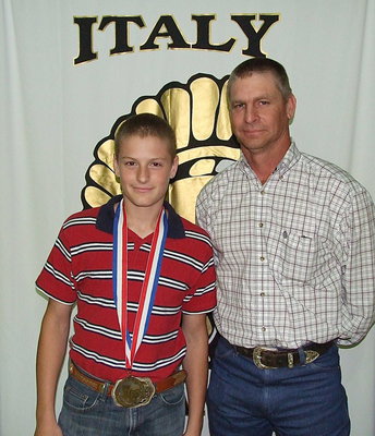 Image: Pictured with his father, Curtis Riddle, team manager, Clay Riddle, displays his State semifinal medal.