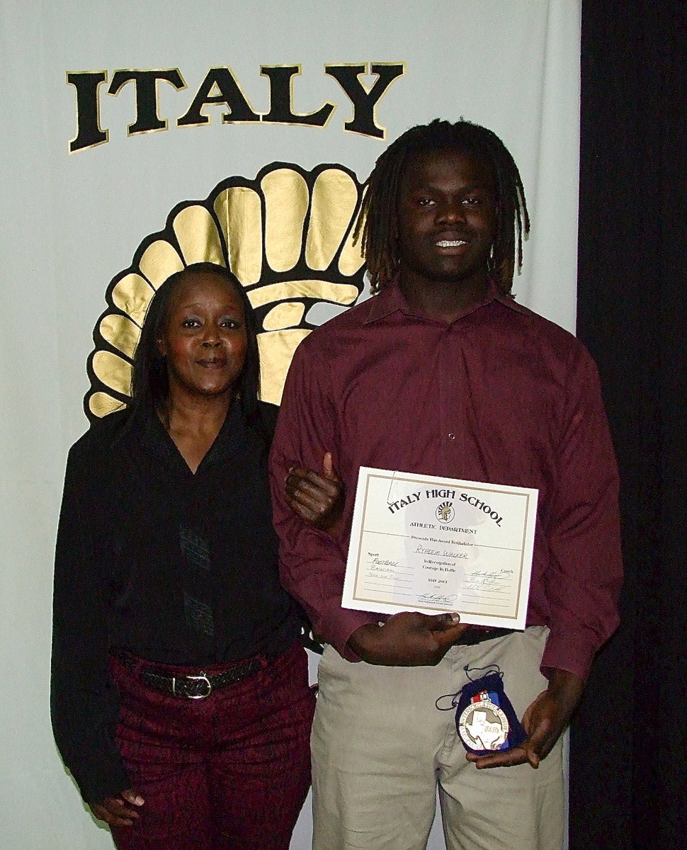 Image: Accompanied by Barbara Mayberry, senior Gladiator, Ryeem Walker, displays his State semifinal medal and certificate of achievement.