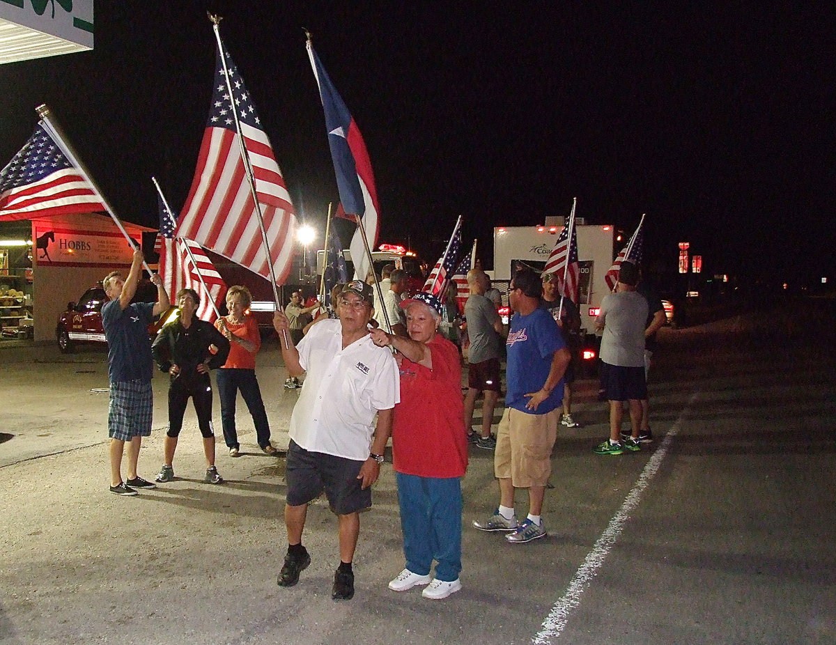 Image: Here he comes! Jessis Castro, and his wife Margie Castro, spot the Birdman emerging from the darkness escorted by emergency vehicles from the Department of Public Safety and the Dallas Fire Department.