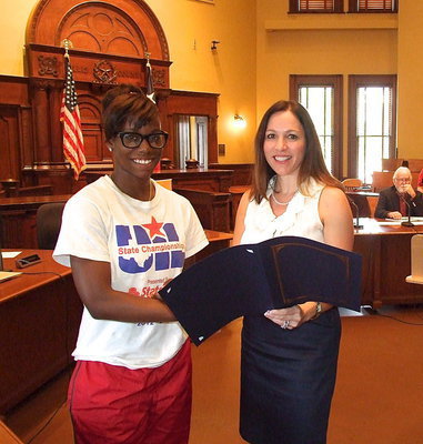 Image: Kortnei Johnson is presented with the proclamation from the Ellis County Commissioners’ Court Judge Carol Bush.