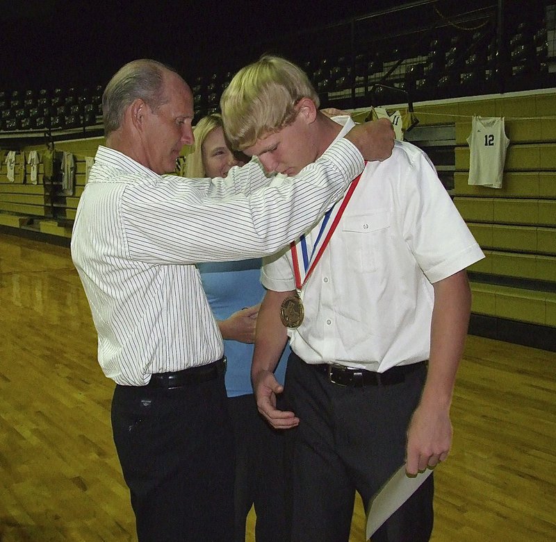 Image: Proud parents Randy and Becky Boyd outfit their son, Cody Boyd, a sophomore, with his State semifinal medal during the 2013 Italy Athletic Banquet.