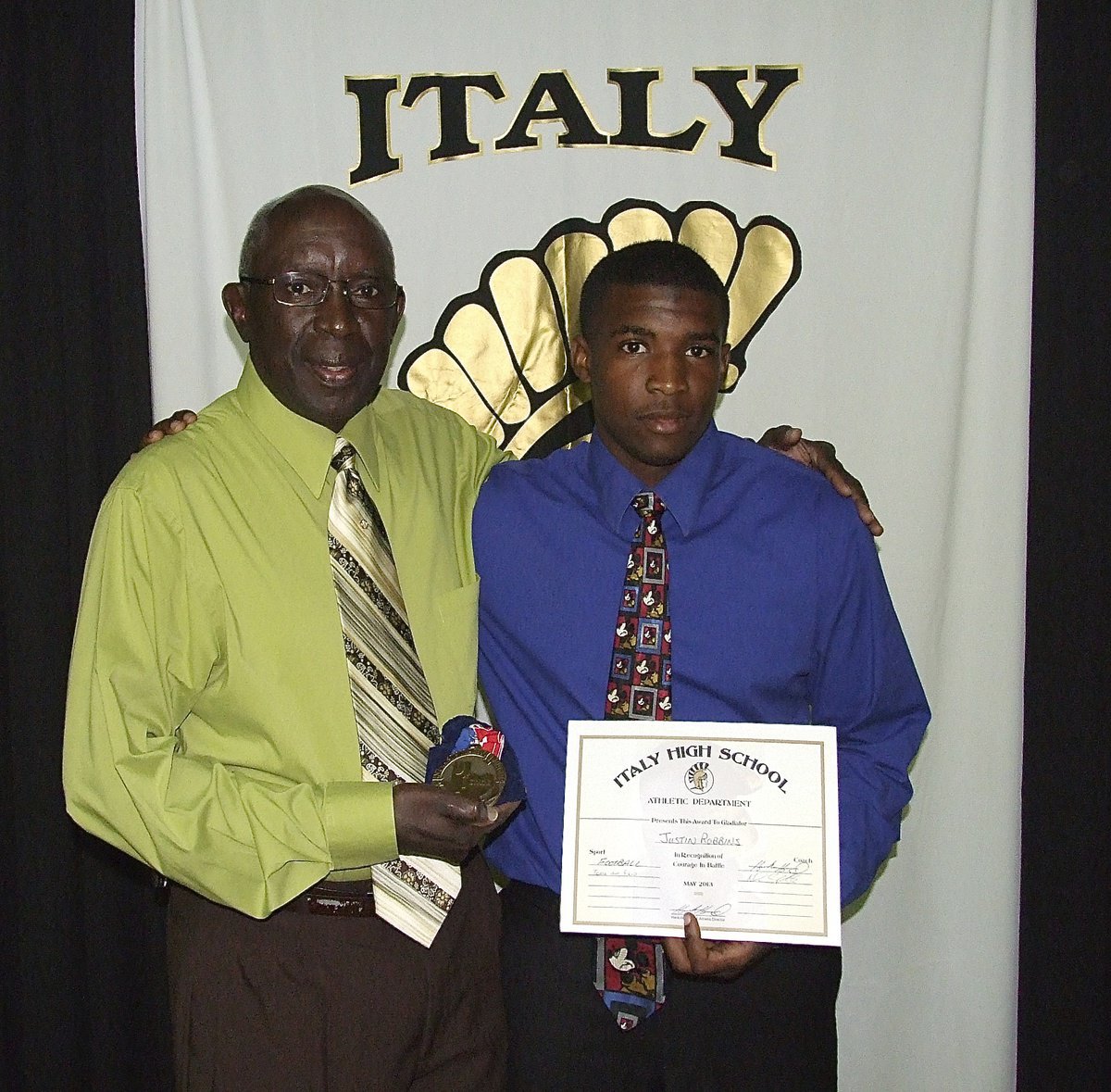 Image: Pictured with his grandfather is Gladiator, Justin Robinson, who displays his State semifinal medal and certificate of achievement.