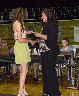 Image: Jozie Perkins, receives her certificate as a member of the JV Lady Gladiator softball team with assistant softball coach Tina Richards presenting.