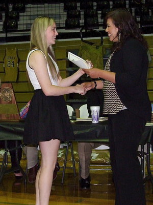 Image: Kelsey Nelson is presented a certificate as a member of Lady Gladiator Volleyball by assistant coach Tina Richards.