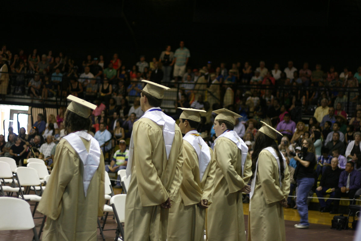 Image: The top 10% GPA students turn and wait for all the graduating seniors to come down the steps and get to their chairs.