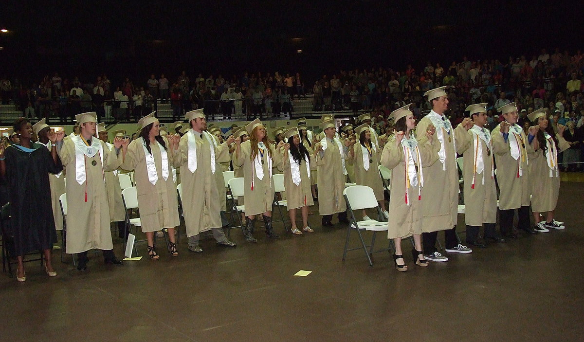 Image: Italy High School 2013 graduates observe a time-honored tradition by joining pinkies during the playing oft he school song.