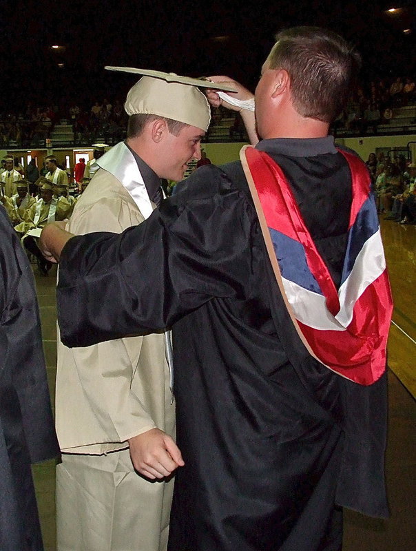 Image: Josh Ward adjusts the tassel for 2013 Italy High School graduate Hayden Woods after Woods received his diploma.