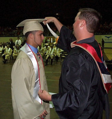 Image: Josh Ward adjusts the tassel for 2013 Italy High School graduate Caden Jacinto after Jacinto received his diploma.