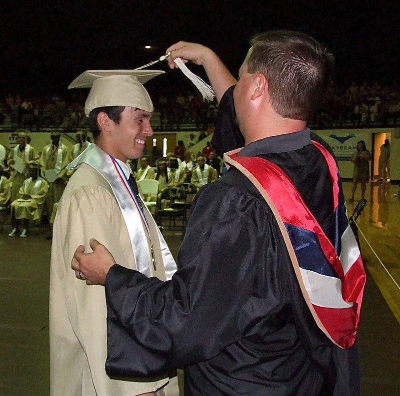 Image: Josh Ward adjusts the tassel for 2013 Italy High School graduate Brandon Jacinto after Jacinto received his diploma.