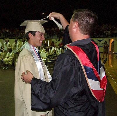 Image: Josh Ward adjusts the tassel for 2013 Italy High School graduate Brandon Jacinto after Jacinto received his diploma.
