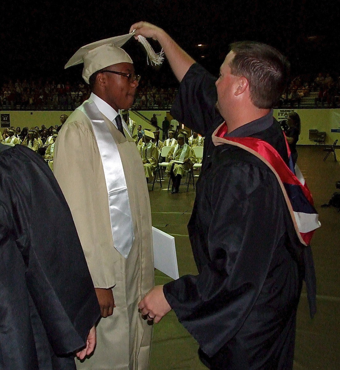 Image: Josh Ward adjusts the tassel for 2013 Italy High School graduate John Hughes after Hughes received his diploma.