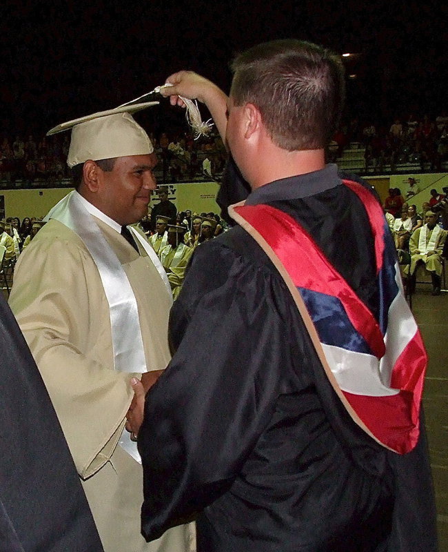 Image: Josh Ward adjusts the tassel for 2013 Italy High School graduate Jonathan Davila after Davila received his diploma.