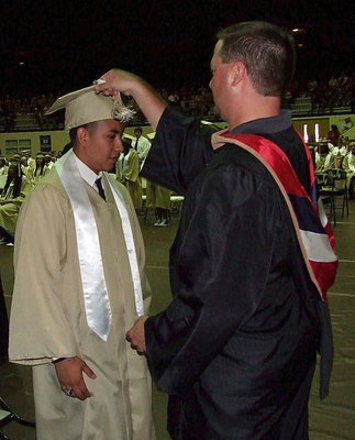 Image: Josh Ward adjusts the tassel for 2013 Italy High School graduate Jonathan Davila after Cortez received his diploma.