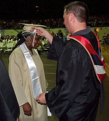 Image: Josh Ward adjusts the tassel for 2013 Italy High School graduate Jameka Copeland after Copeland received her diploma.