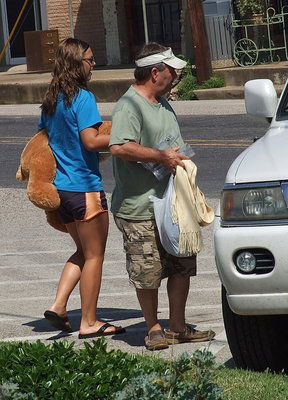Image: Bailey Eubank and her father, Larry Eubank, help shoppers with their items.