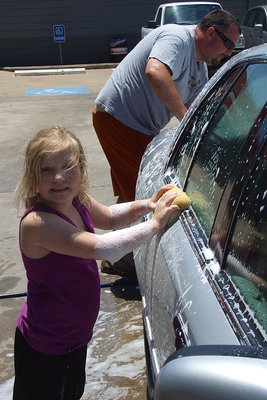 Image: 5-year old Azlin Itson, the reining 2013 Ellis Count Cinderella Tot washes cars with her father, Aaron Itson, to help raise money so Azlin can continue her quest for a State title as a beauty queen.