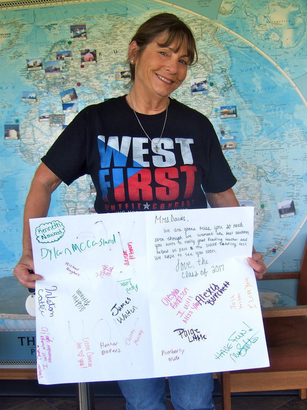 Image: Here is Margie holding up a big ‘Thank You’ card from her students!