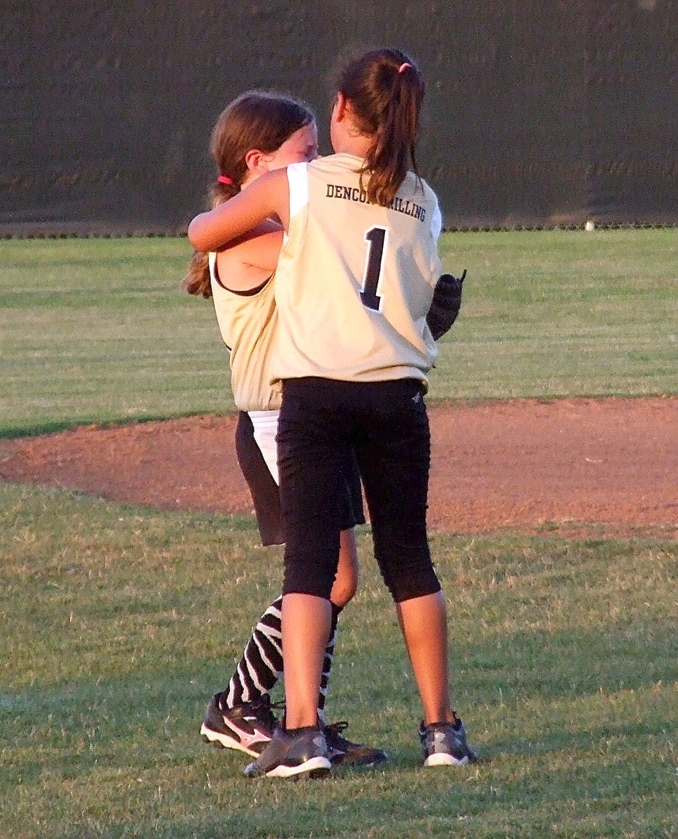 Image: Italy’s third baseman, Cadence Ellis rushes over to console her teammate and shortstop, Kinley Cate, with a big hug after Cate was hit in the face with the ball.