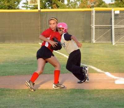 Image: Italy’s, Evie South exits first base with both teams scrambling for the win.