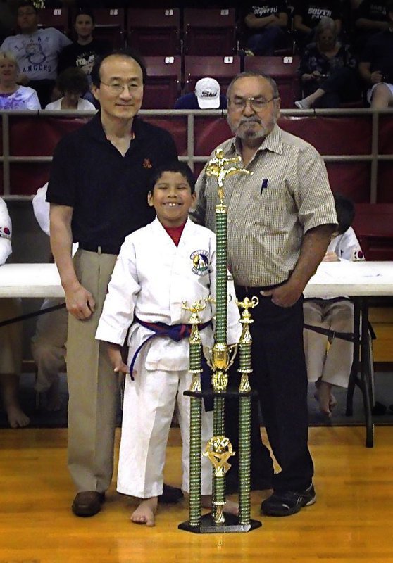 Image: Italy’s Nick Sam is pictured with Grand Master Park-Houston and Master Charles Kight-Chief Instructor of the Hillsboro Unified Tae Kwon Do School who present Sam with a trophy that rewards his earning All A’s during the 2012-2013 school year as a a student at Italy Stafford Elementary.