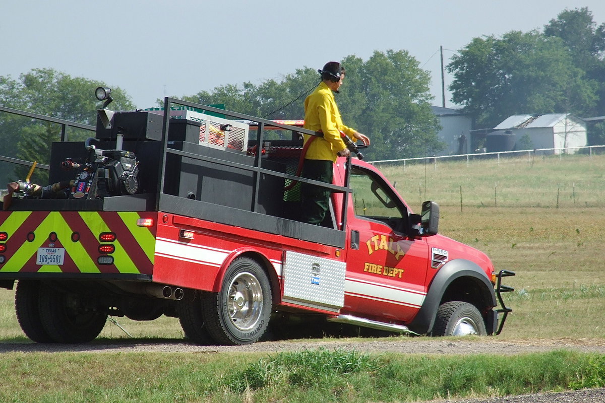 Image: Italy firefighter Brandon Jacinto prepares to spray the backside of the fire to keep the burn from spreading into a nearby tree line.