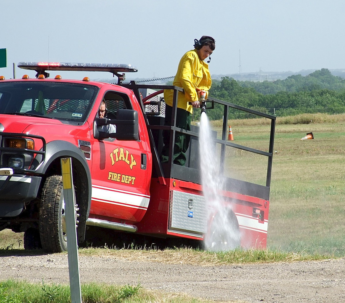 Image: Italy firefighter Brad Chambers drives fellow firefighter Brandon Jacinto within range of the flames.