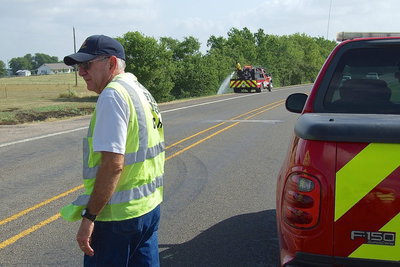 Image: Italy Fire Chief Donald Chambers directs traffic with his fire crew in a vulnerable position along the edge of Highway 77.