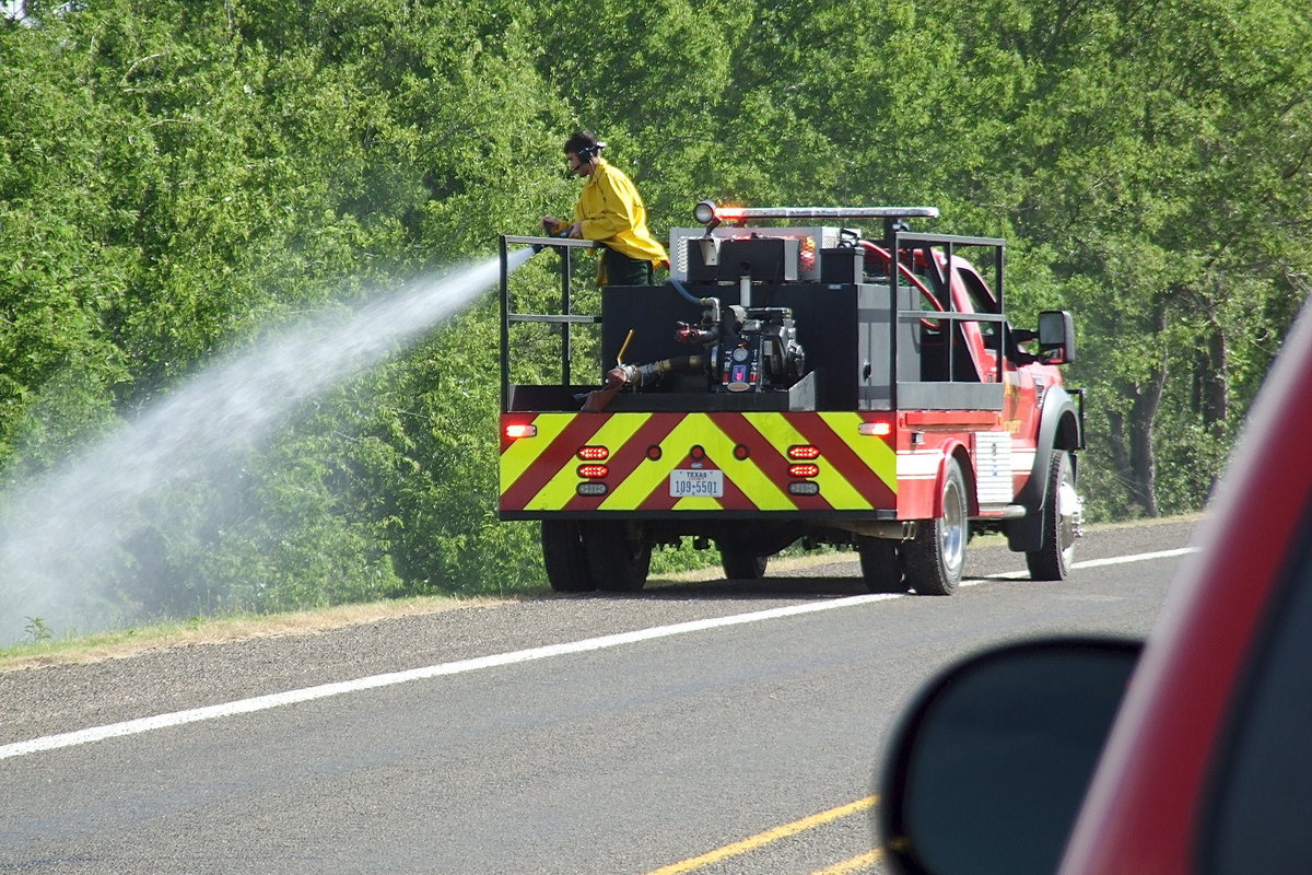 Image: Italy firefighter Brandon Jacinto works the base of the tree line to keep the grass fire from spreading into the thick brush.